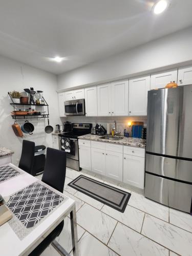 a kitchen with white cabinets and a stainless steel refrigerator at Zen Oasis in Newark