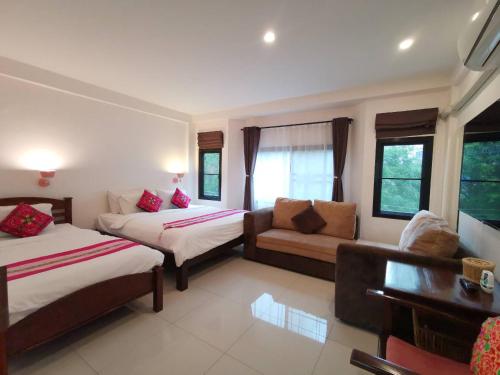 Habitación de hotel con 2 camas y sofá en Sasima House, en Chiang Mai
