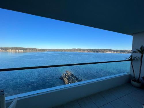 a large window with a view of a large body of water at Departamento Esmeralda Pingueral in Dichato