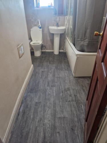 a bathroom with a toilet and a sink and a tub at Cozy Bedroom in Spacious House Manchester in Rochdale
