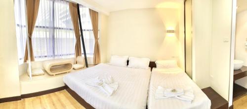 two beds in a room with a window at ABC SO Hotel Bangkok in Bangkok