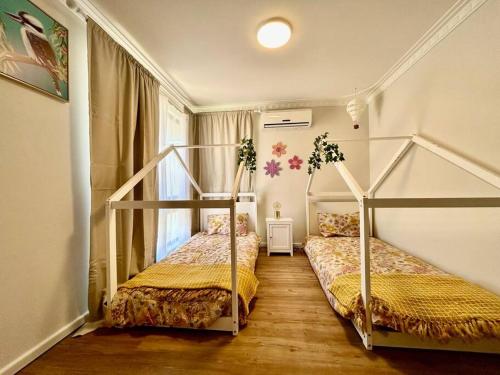 The Wildflower- Luxury Home Stay في Utakarra: غرفة نوم بسريرين بطابقين ودرج