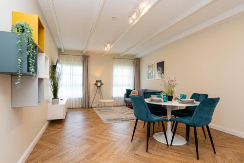 a living room with a table and chairs at Vaivutės apartamentai No1 in Darbėnai