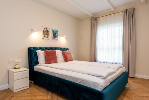 a bedroom with a large bed with a blue headboard at Vaivutės apartamentai No1 in Darbėnai