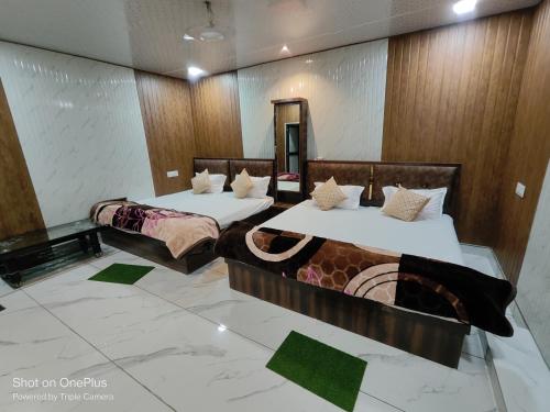 duas camas num quarto de hotel com angular em SHREE NAKODA HOME STAY em Ujaim