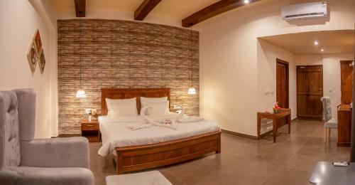 a bedroom with a bed and a brick wall at Eko Resort - Jim Corbett in Belparāo