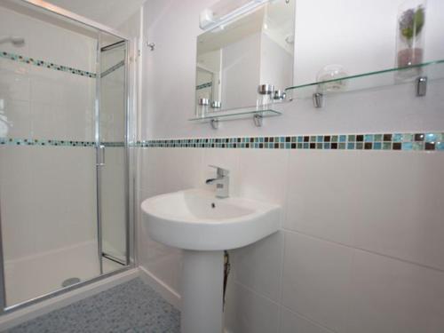 a white bathroom with a sink and a shower at 3 bed in Fishguard 37270 in Fishguard