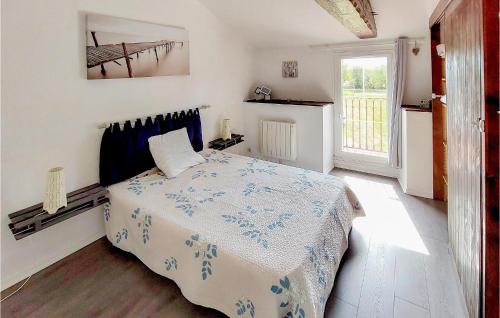 a bedroom with a bed with a blue and white blanket at Awesome Home In Argenton Leglise With Private Swimming Pool, Can Be Inside Or Outside in Argenton lʼÉglise