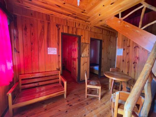 a room with a bench and a table in a cabin at Saint Joseph Inn in Sagada