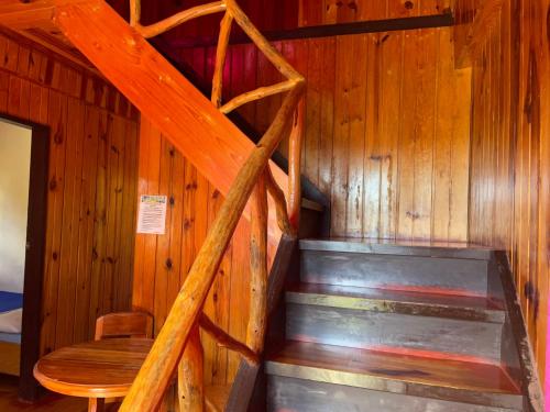 a wooden staircase in a room with a table and a chair at Saint Joseph Inn in Sagada