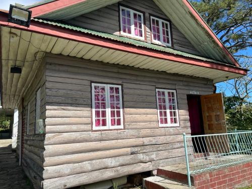 a small wooden house with two windows and a porch at Saint Joseph Inn in Sagada