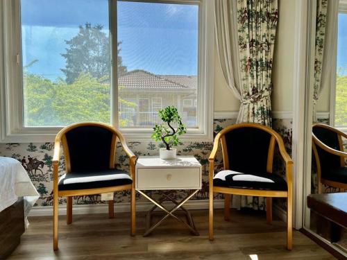 2 sillas y una mesa en una habitación con ventana en Master Bedroom with Two Queen Sized Bed en Richmond