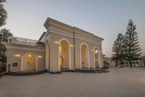 a large white building with arches and a courtyard at CSR Landmark Resorts in Coimbatore
