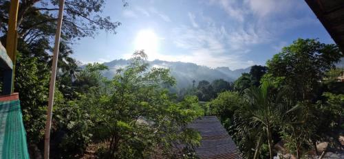 a view of the mountains from a house with trees at CARIBbEAN Paradise Hotel in Lanquín