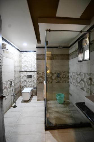 a bathroom with a shower and a sink and a toilet at Hotel Jataka Inn in Bodh Gaya