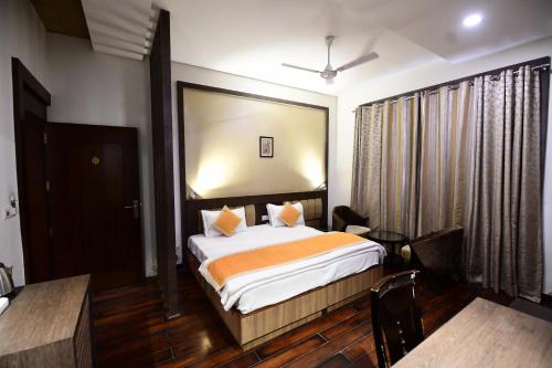 a hotel room with a bed and a table and chairs at Hotel Jataka Inn in Bodh Gaya