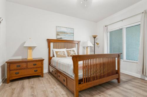 a bedroom with a bed and a nightstand and a window at Shores Of Panama 1403 in Panama City Beach