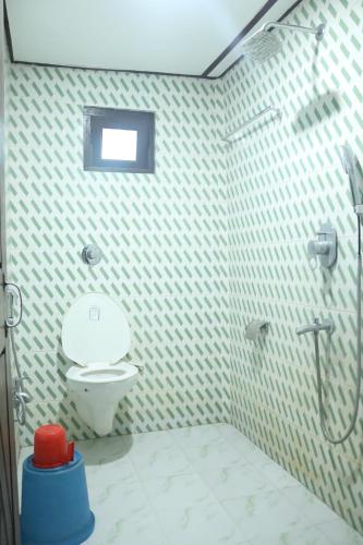 a bathroom with a shower and a toilet in it at Prakriti neerh in Jyoti Gaon