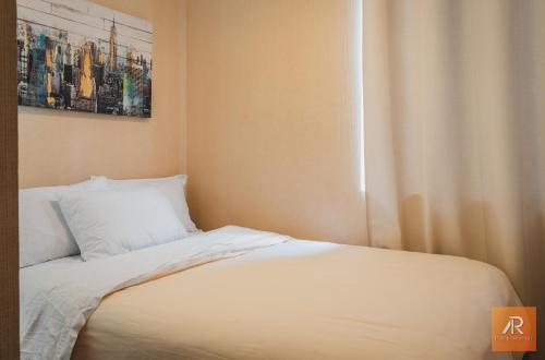 een bed met witte lakens en kussens naast een raam bij Arrendamiento Peru in Lima