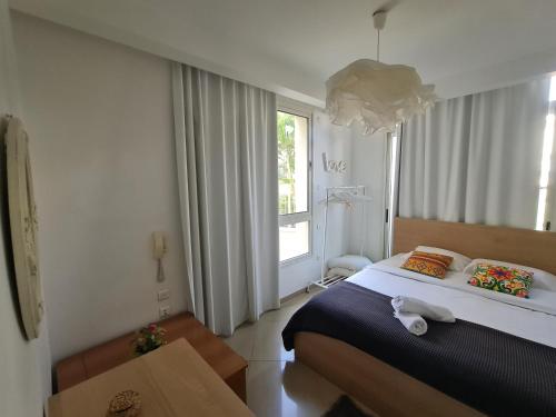 a bedroom with a large bed and a window at De Golf Luxury Resort Apartments in Eilat