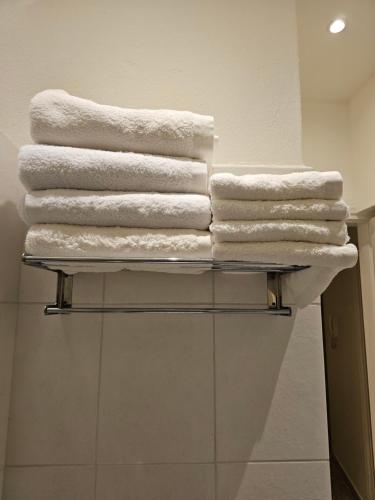een stapel handdoeken op een plank in een badkamer bij Elektras Apartment στο κέντρο της Λάρισας με δωρεάν πάρκιγκ in Larisa