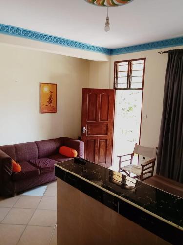 ein Wohnzimmer mit einem Sofa und einem Tisch in der Unterkunft Mariella homes in Ukunda