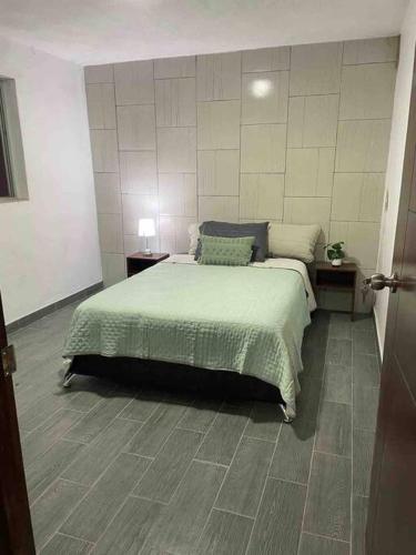 a bedroom with a bed and two night stands and two tables at Casa Rose Gold in Guadalajara