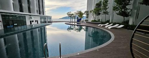 a swimming pool in a building next to a building at Summer Studio Apartment at Kota Kinabalu City Centre in Kota Kinabalu