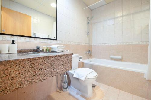 a bathroom with a toilet and a sink and a tub at HomesGetaway - Stylish 1BR Armada Cluster P in Dubai