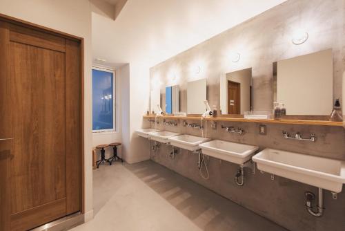 a bathroom with a row of sinks and mirrors at Hotel Relief Kokura Annex in Kitakyushu