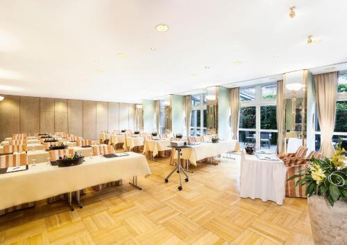 a banquet hall with tables and chairs and windows at Best Western Premier Grand Hotel Russischer Hof in Weimar