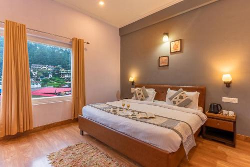 a bedroom with a large bed with a large window at Hotel Vista Bhowali, Nainital - Vegetarian in Bhowāli