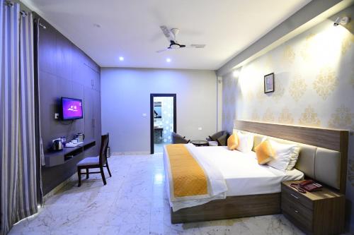 a hotel room with a bed and a desk at Hotel Jataka Inn in Bodh Gaya