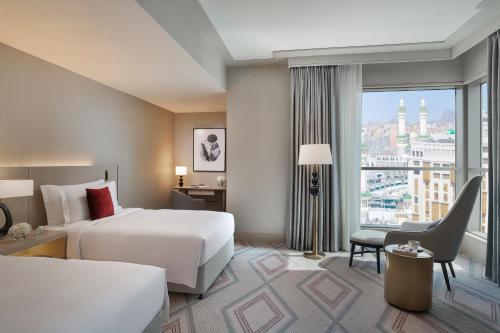 a hotel room with a bed and a large window at Jumeirah Jabal Omar Makkah in Makkah