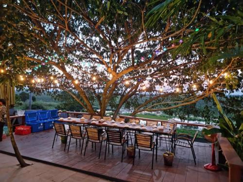 uma mesa e cadeiras debaixo de uma árvore com luzes em Chomka Thnong Resort 