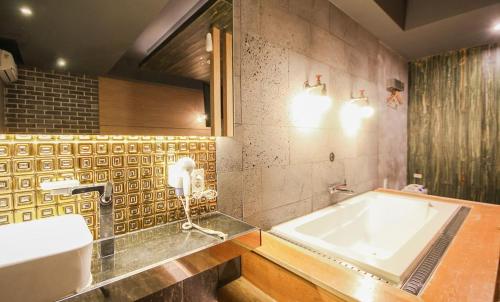 a bathroom with a tub and a sink at Hotel 109 in Busan