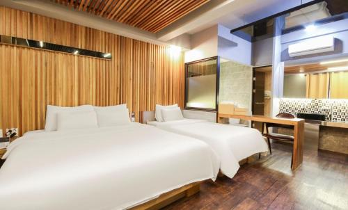 1 Schlafzimmer mit 2 weißen Betten und einem Schreibtisch in der Unterkunft Hotel 109 in Busan