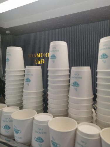 a stack of plates and cups on a shelf at Diamond Star Hotel فندق النجمة الماسية in Seeb