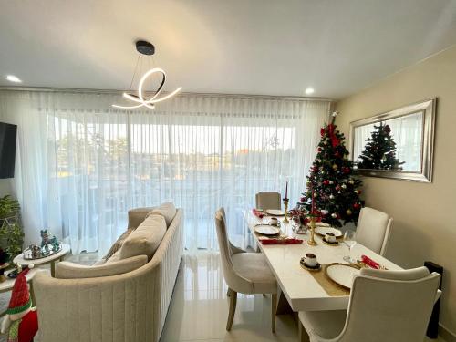 Lujoso apartamento en el norte في مونتيريا: غرفة معيشة مع طاولة وشجرة عيد الميلاد