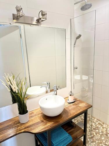une salle de bain avec un lavabo blanc et une douche dans l'établissement Appart design, plein centre Marseille, à Marseille