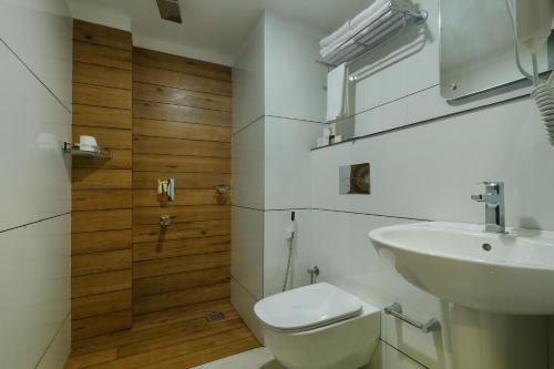 a bathroom with a white toilet and a sink at The HEARTLAND Hotel in Trivandrum