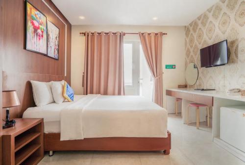 a hotel room with a bed and a television at C'Lavie Hotel - Saigon Airport Hotel in Ho Chi Minh City