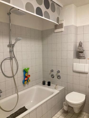 a white bathroom with a tub and a toilet at 3 Zi Wohnung Haustiere willkommen im Markgräflerland Dreiländereck in Schliengen