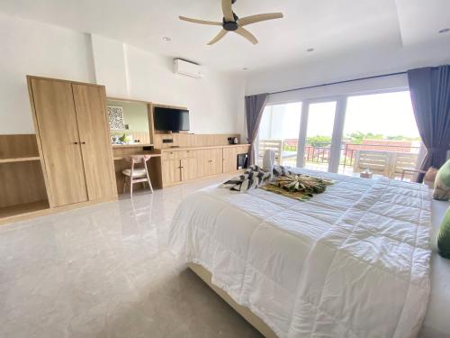 una camera con un grande letto e un ventilatore a soffitto di Solaluna Beach Homestay ad Amed