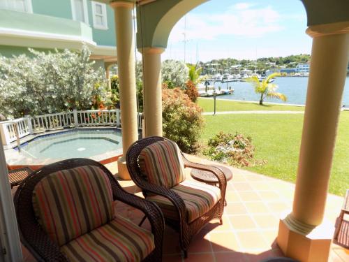 a porch with two chairs and a swimming pool at The Pelican #3 - Spacious 3 bedroom 2,5 bath waterfront townhome in the heart of Rodney Bay, townhouse in Rodney Bay Village