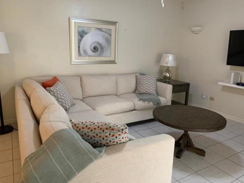 a living room with a white couch and a table at Bay View #7 - 3 bedroom, 3,5-bath waterfront townhouse in a gated community in Rodney Bay townhouse in Gros Islet