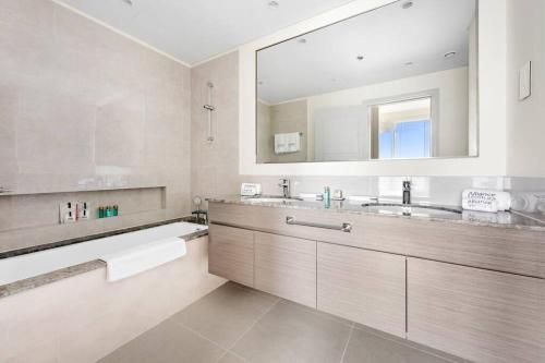 ein Badezimmer mit zwei Waschbecken und einem großen Spiegel in der Unterkunft Lavish Forte Tower 2BR in the Heart of Downtown in Dubai