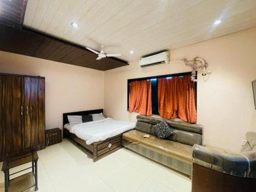 een slaapkamer met een bed en een raam bij Ivy Tungarli Dream Villa (4 BHK - Indoor Pool), Lonavala in Lonavala