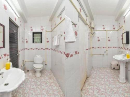 een witte badkamer met een toilet en een wastafel bij Ivy Tungarli Dream Villa (4 BHK - Indoor Pool), Lonavala in Lonavala