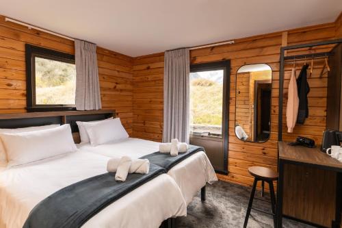 a bedroom with a large bed with towels on it at Haka House Aoraki Mt Cook in Mount Cook Village